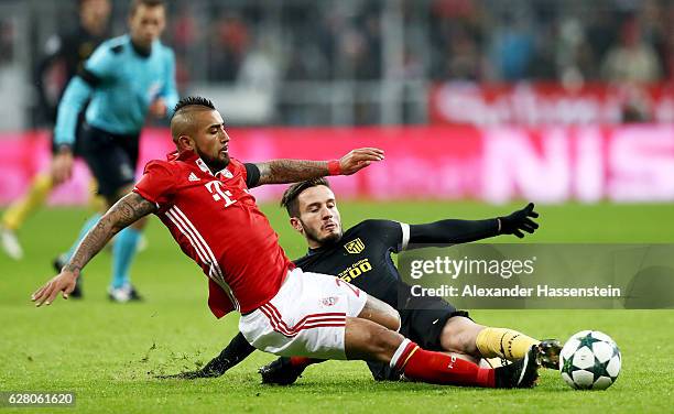 Arturo Vidal of Bayern battles for the ball with Saul Nuguez of Atletico Madrid during the UEFA Champions League match between FC Bayern Muenchen and...