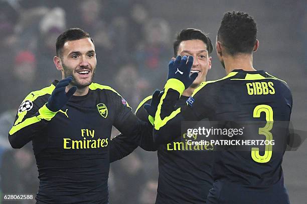 Arsenal's Spanish forward Lucas Perez celebrates with his teammate Arsenal's German midfielder Mesut Ozil and Arsenal's English defender Kieran Gibbs...