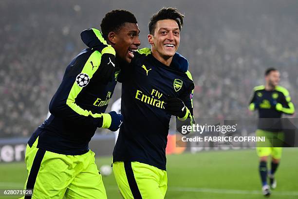 Arsenal's Nigerian forward Alex Iwobi celebrates after scoring a goal with his teammate Arsenal's German midfielder Mesut Ozil during the UEFA...