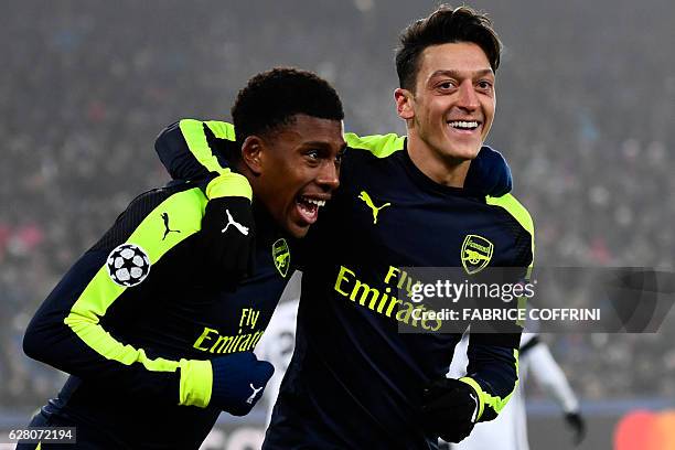 Arsenal's Nigerian forward Alex Iwobi celebrates after scoring a goal with his teammate Arsenal's German midfielder Mesut Ozil during the UEFA...