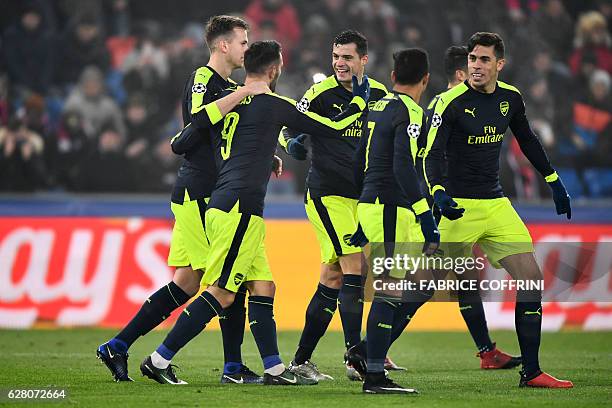 Arsenal's Spanish forward Lucas Perez celebrates after scoring a goal with his teammates during the UEFA Champions league Group A football match...