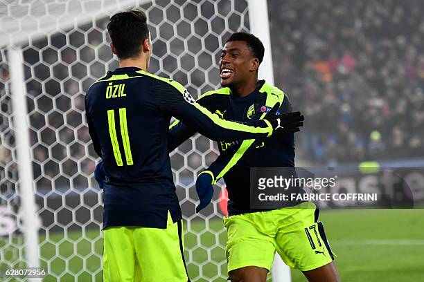 Arsenal's Nigerian forward Alex Iwobi celebrates after scoring a goal with his teammate Arsenal's German midfielder Mesut Ozil during the UEFA...