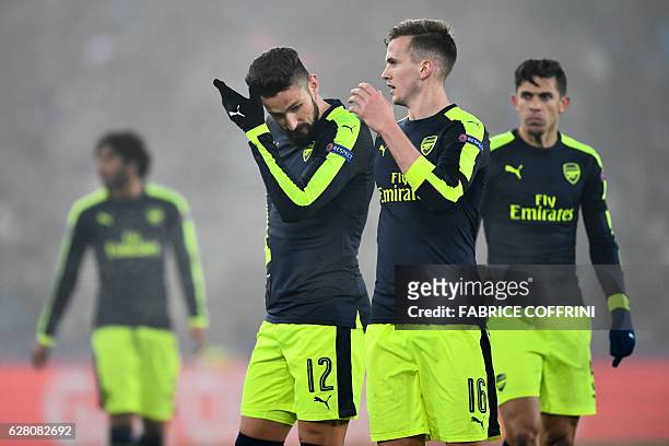 Arsenal's French forward Olivier Giroud and Arsenal's English defender Rob Holding react at the end of the UEFA Champions league Group A football...