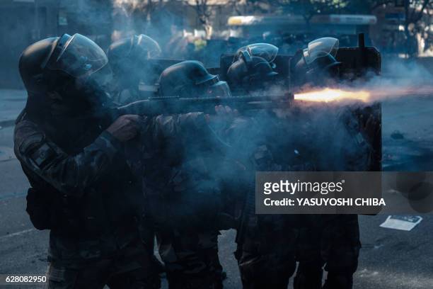 Riot police shoot rubber bullets during a civil servants protest against austerity measures in front of the Rio de Janeiro state Assembly, where...