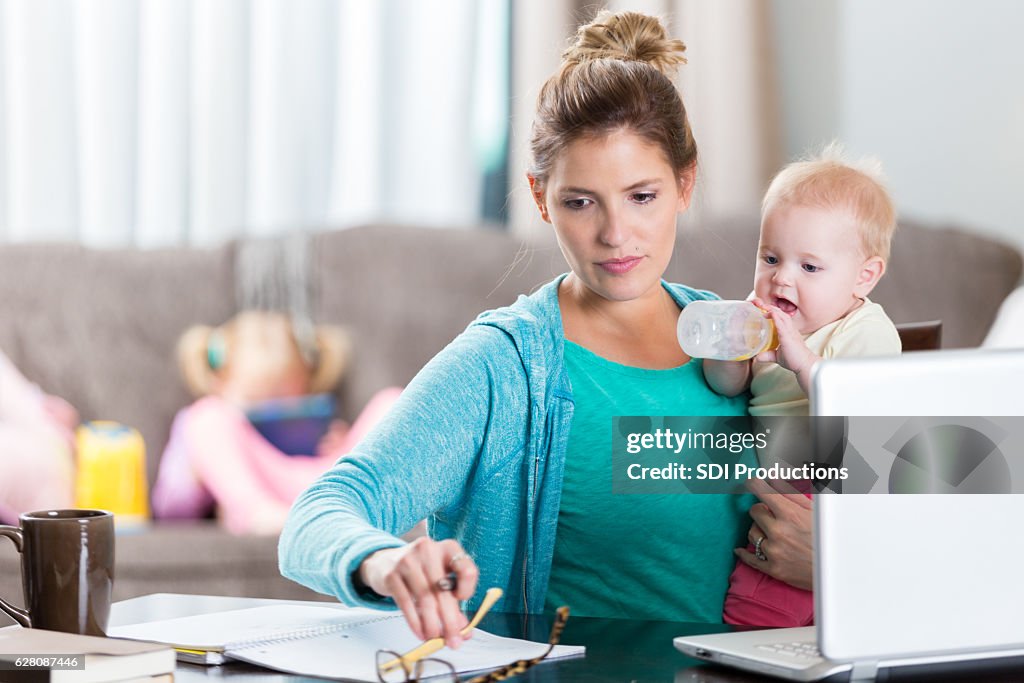 Serious holds baby while working from home