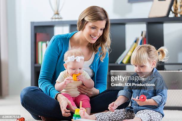 maman ou nounou joue avec les enfants à la maison - nurse photos et images de collection