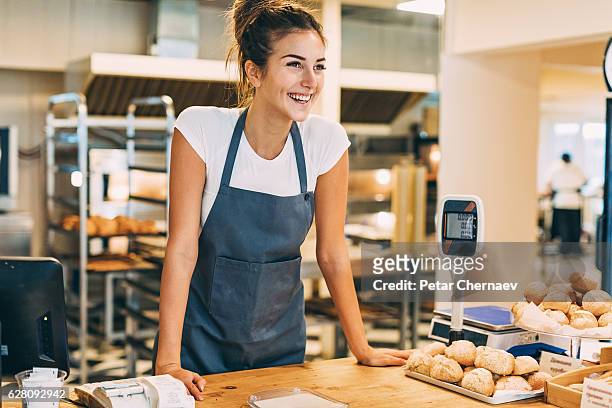 comptoir d’enregistrement dans la boulangerie - apron woman photos et images de collection