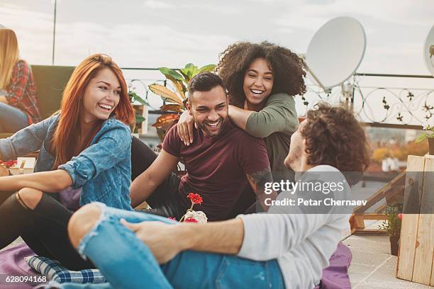 multi-ethnic couples chatting on the rooftop - city friends sun bildbanksfoton och bilder