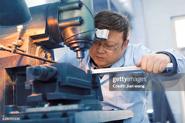 factory worker using drilling machine - factory workers in vietnam stock pictures, royalty-free photos & images