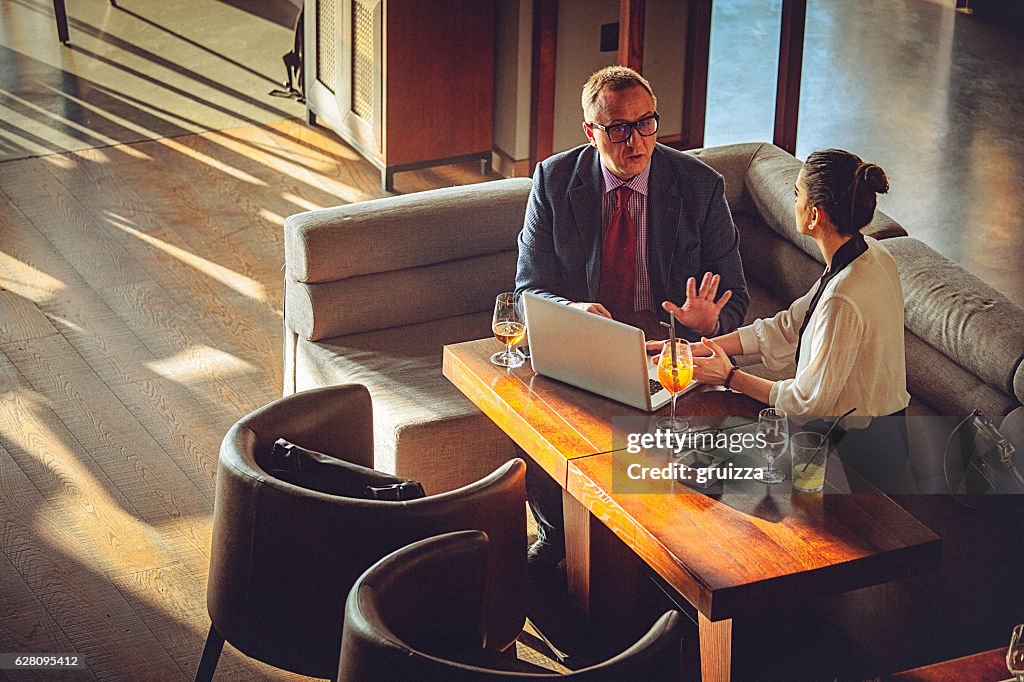 Young business woman and man having conversation at a restaurant