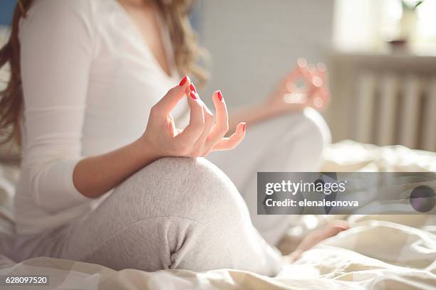 young woman meditating - bedtime stock pictures, royalty-free photos & images