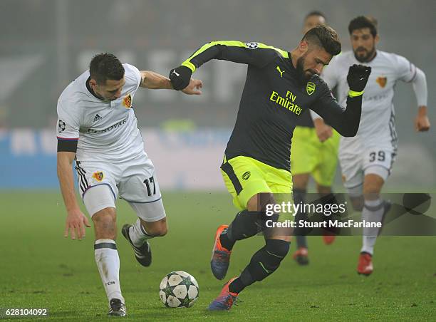 Olivier Giroud of Arsenal takes on Marek Suchy of Basel during the UEFA Champions League match between FC Basel and Arsenal at St. Jakob-Park on...