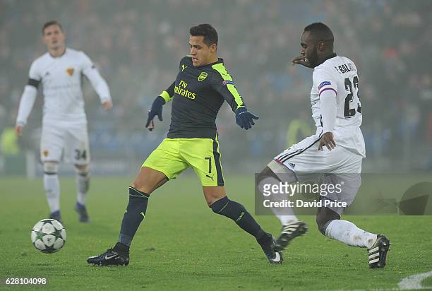 Alexis Sanchez of Arsenal takes on Eder Balanta of Basel during the UEFA Champions League match between FC Basel and Arsenal at St. Jakob-Park on...