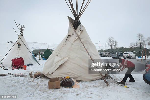 Neil Gordon secures the base of a teepee at Oceti Sakowin Camp as blizzard conditions grip the area around the Standing Rock Sioux Reservation on...