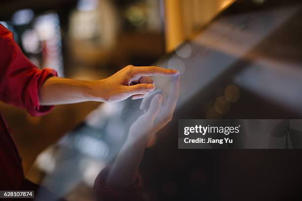 a hand in red about to touch an interactive directory guide - interattività foto e immagini stock