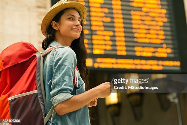 young woman checking her train in time board - backpacker woman bildbanksfoton och bilder