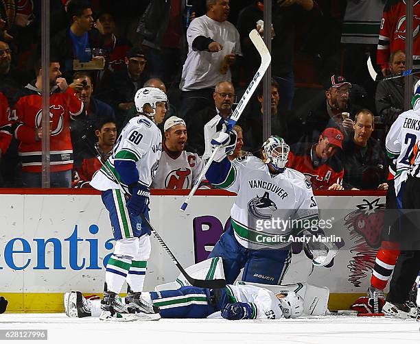 Jacob Markstrom of the Vancouver Canucks calls for medical attention as teammate Philip Larsen lays on the ice after being injured during the game...