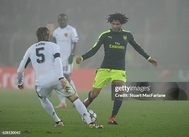 Mohamed Elneny of Arsenal challenges Michael Lang of Basel during the UEFA Champions League match between FC Basel and Arsenal at St. Jakob-Park on...