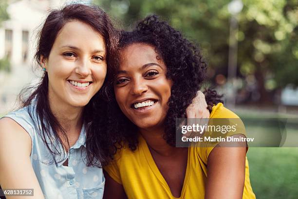 smiling mixed race girls spending time together - girlfriend stockfoto's en -beelden