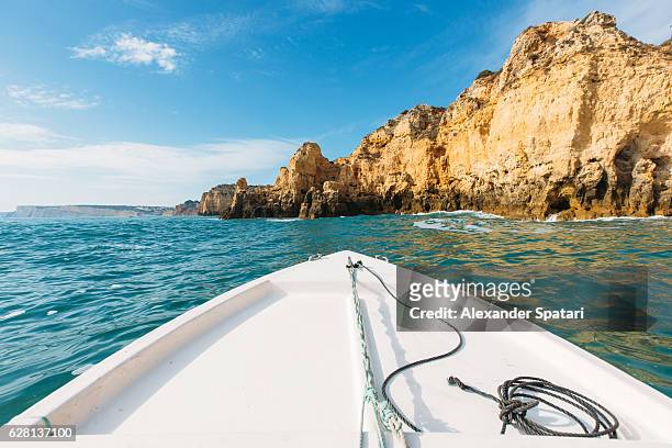 sailing the boat among rock formations in algarve, portugal - ponta da piedade imagens e fotografias de stock