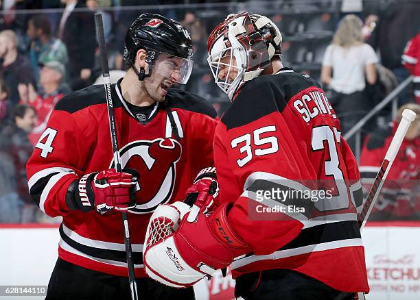 Adam Henrique and Cory Schneider of the New Jersey Devils celebrate the 3-2 win over the Vancouver Canucks on December 6, 2016 at Prudential Center...