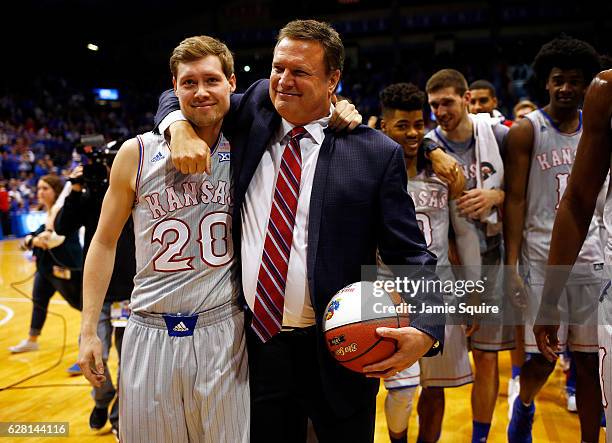 Head coach Bill Self of the Kansas Jayhawks hugs son Tyler Self after ebing honored for his 600th win following the game against the UMKC Kangaroos...