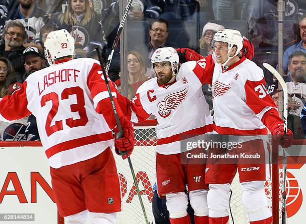 Brian Lashoff of the Detroit Red Wings joins teammates Henrik Zetterberg and Anthony Mantha as they celebrate a second period goal against the...