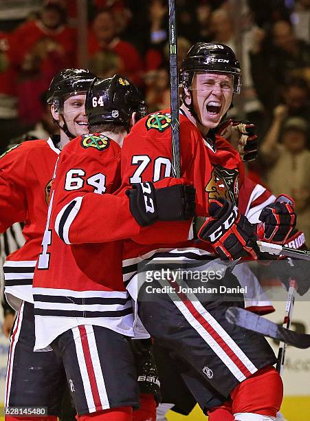 Dennis Rasmussen of the Chicago Blackhawks celebrates his second period goal with Richard Panik and Tyler Motte at the United Center on December 6,...