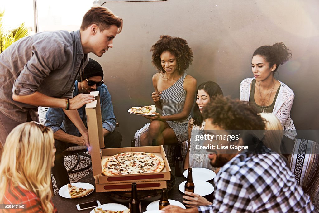 Gruppe von Freunden mit Bier und Pizza