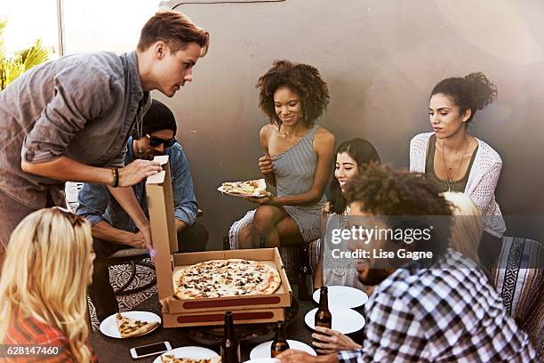 group of friends having beers and pizza - lise gagne stock pictures, royalty-free photos & images