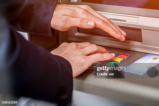 entering atm cash machine pin code - safety pin stockfoto's en -beelden