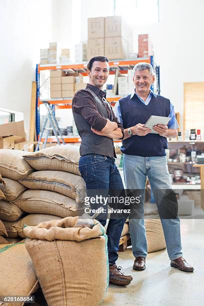 glückliche geschäftspartner im kaffeelager - jute stock-fotos und bilder