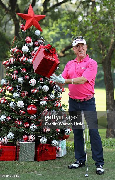 Miguel Angel Jimenez of Spain poses with a present by a Christmas tree during the pro-am ahead of the UBS Hong Kong Open at The Hong Kong Golf Club...
