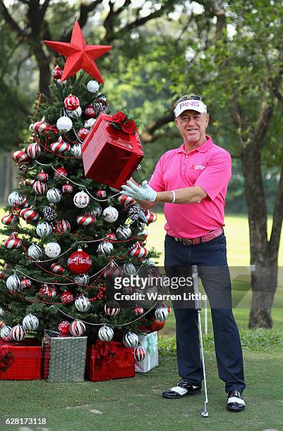 Miguel Angel Jimenez of Spain poses with a present by a Christmas tree during the pro-am ahead of the UBS Hong Kong Open at The Hong Kong Golf Club...