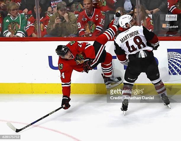Richard Panik of the Chicago Blackhawks hits the ice after colliding with Jordan Martinook of the Arizona Coyotes at the United Center on December 6,...