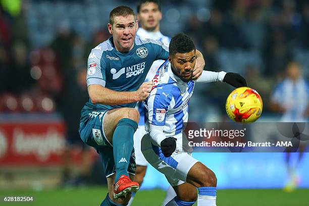 Jake Buxton of Wigan Athletic tackles Elias Kachunga of Huddersfield Town during the Sky Bet Championship match between Huddersfield Town and Wigan...