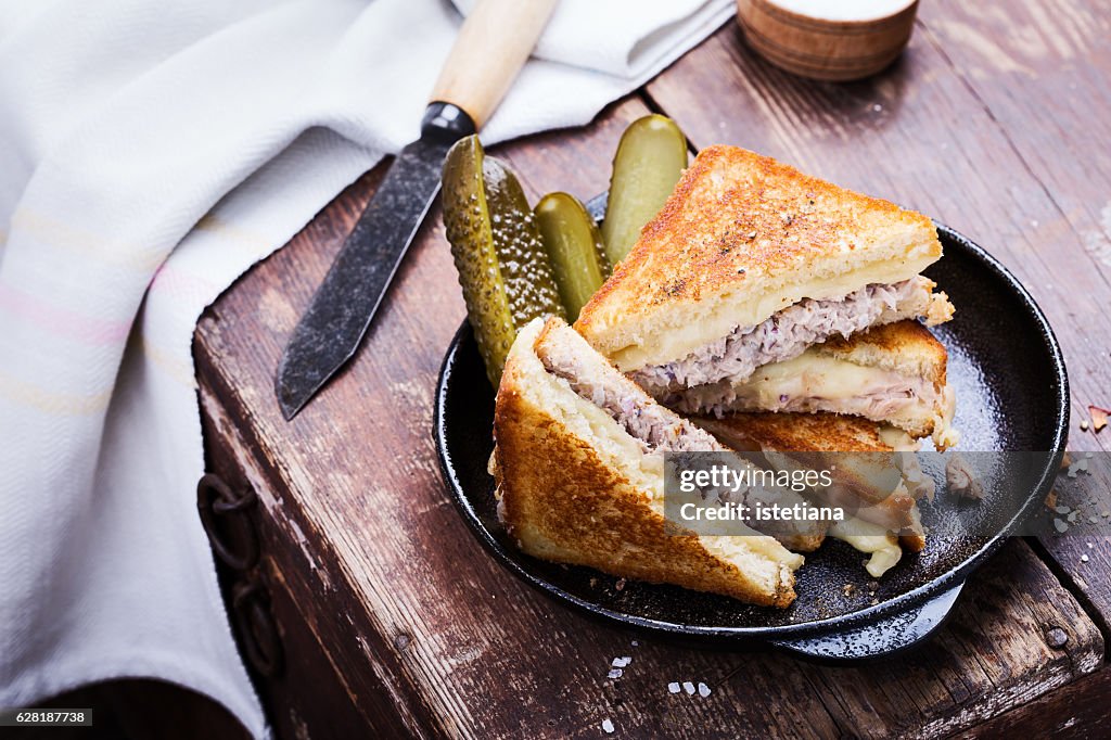 Homemade tuna melt sandwich served warm with pickles