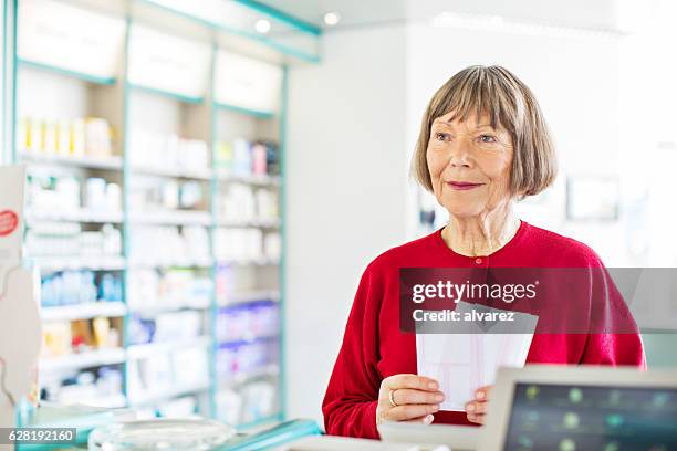 senior female customer at pharmacy store - cure berlin 2016 stockfoto's en -beelden