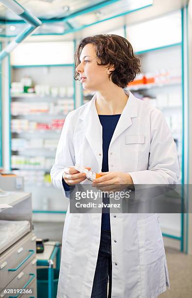 young female pharmacist at checkout counter - cure berlin 2016 stock pictures, royalty-free photos & images