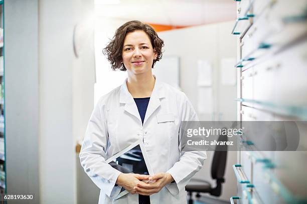 female druggist standing with a digital tablet - cure berlin 2016 stock pictures, royalty-free photos & images