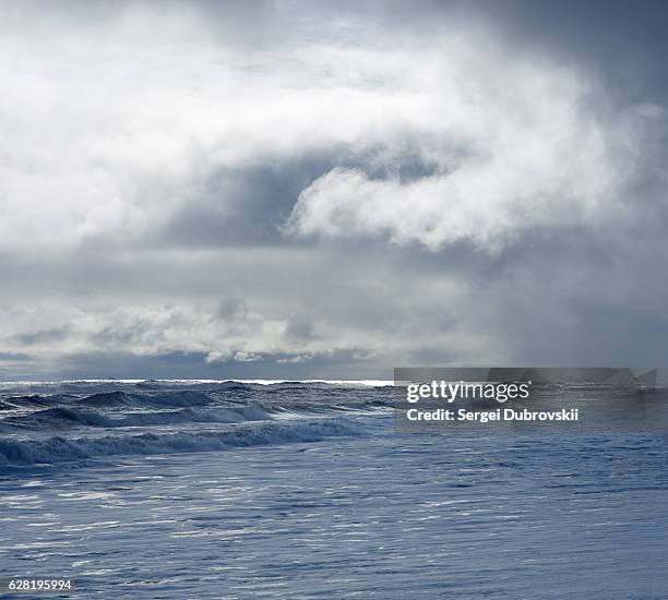 dramatic cloudy sky over dark water ripple surface sea, sunlight - north pacific stock pictures, royalty-free photos & images