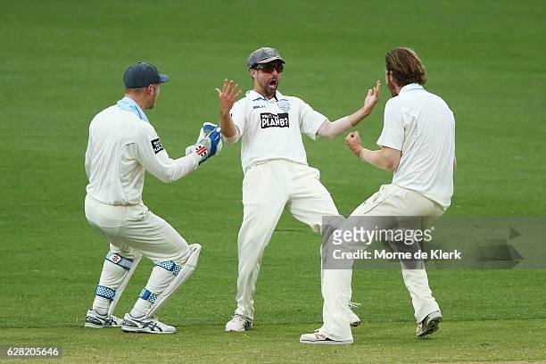 Blues players celebrate with teammate Ed Cowan after he run-out Sam Raphael of the SA Redbacks with a direct hit during day three of the Sheffield...