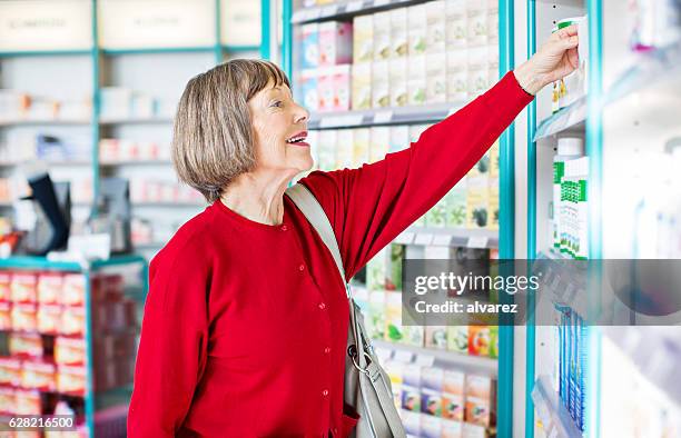 senior female customer buying medicine - cure berlin 2016 stockfoto's en -beelden