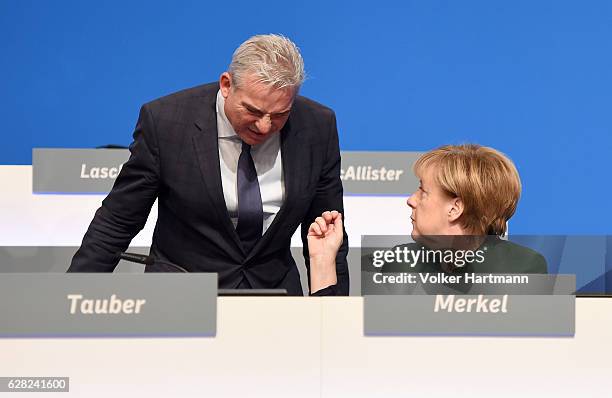 Chancellor and Chairwoman of the German Christian Democrats Angela Merkel speakes at the podium with the German Minister of the Interior in...