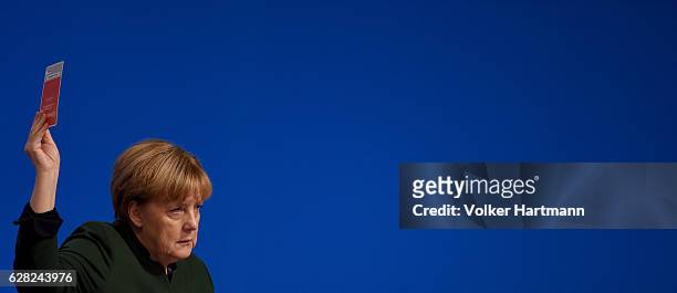 Chancellor and Chairwoman of the German Christian Democrats Angela Merkel holds a voting cardl during the 29th annual congress of the Christian...