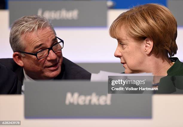 Chancellor and Chairwoman of the German Christian Democrats Angela Merkel speaks at the podium with the German Minister of the Interior in...