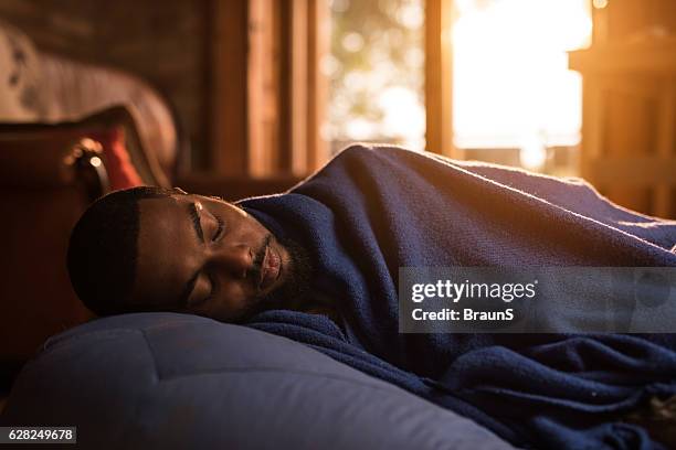 african american man taking a nap on a bean bag. - sleeping man stock pictures, royalty-free photos & images