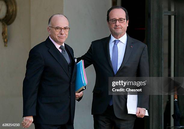 French President Francois Hollande and newly appointed Prime Minister Bernard Cazeneuve leave the Elysee Palace after the first cabinet meeting with...