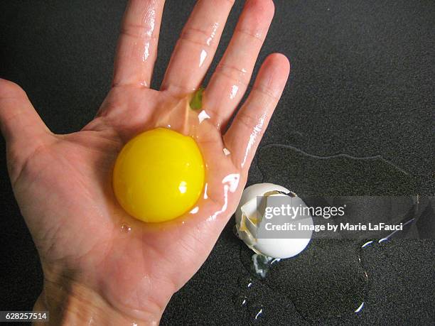 raw egg cracked in palm of hand - egg white omelet stock pictures, royalty-free photos & images