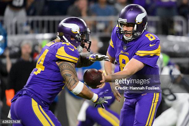 Sam Bradford of the Minnesota Vikings hands the ball to teammate Matt Asiata during the game on December 1, 2016 at US Bank Stadium in Minneapolis,...